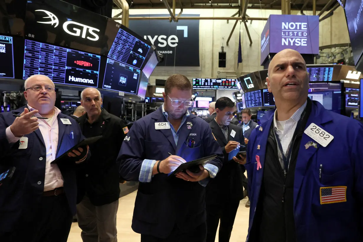 FILE PHOTO: Traders work on the floor of the NYSE in New York