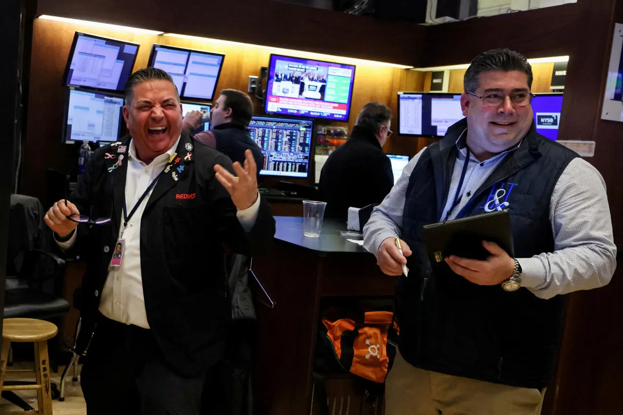 Traders react after the closing bell on the floor of the NYSE in New York