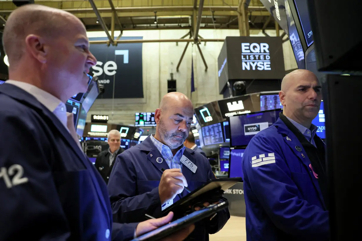 FILE PHOTO: Traders work on the floor of the NYSE in New York