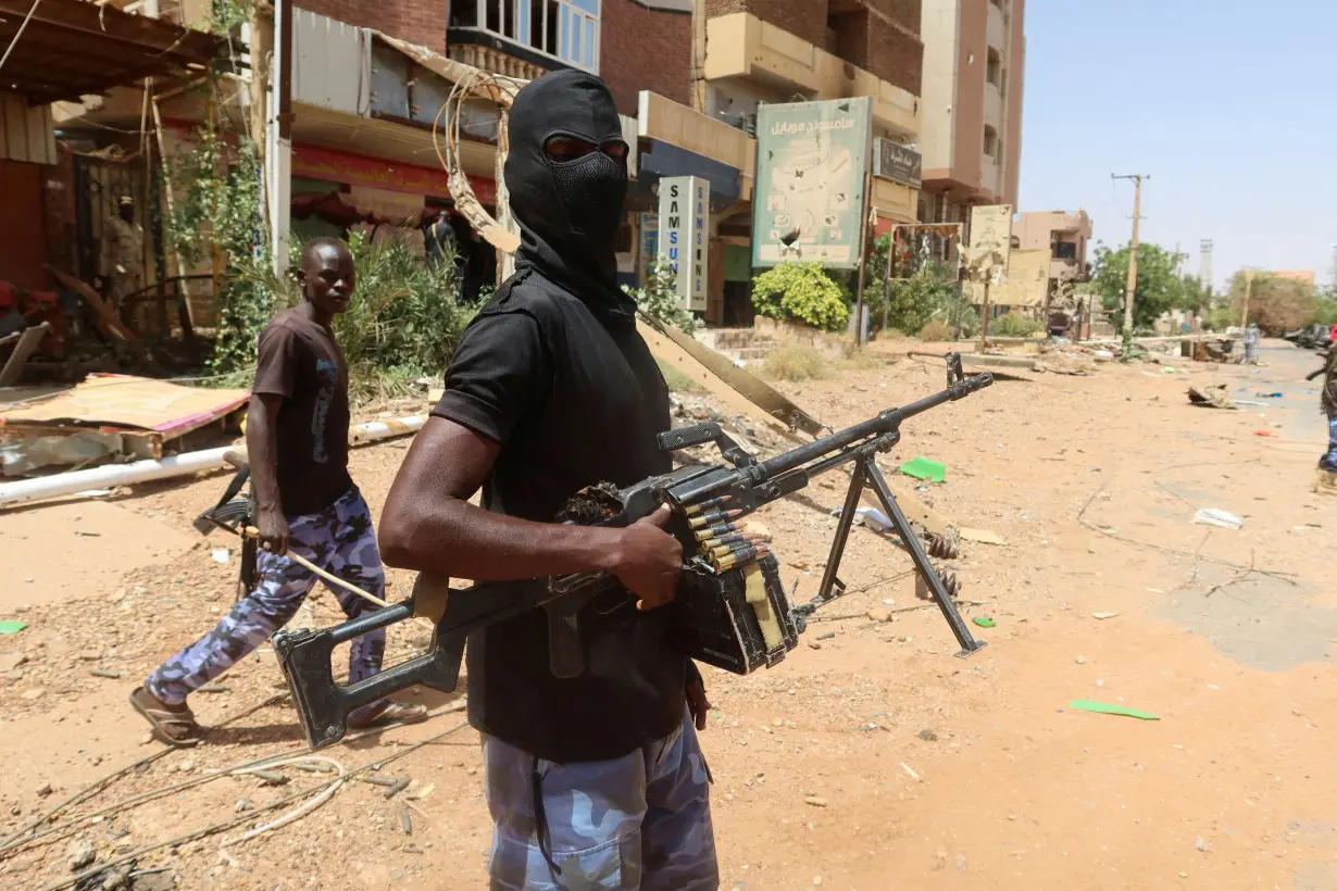 FILE PHOTO: A member of Sudanese armed forces looks on as he holds his weapon in the street in Omdurman