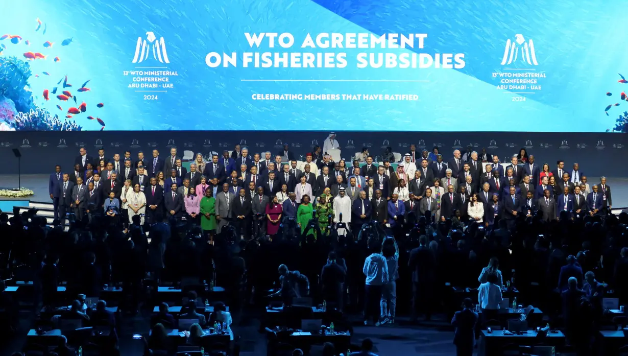 FILE PHOTO: Delegates pose for a family photo during the 13th WTO ministerial conference in Abu Dhabi