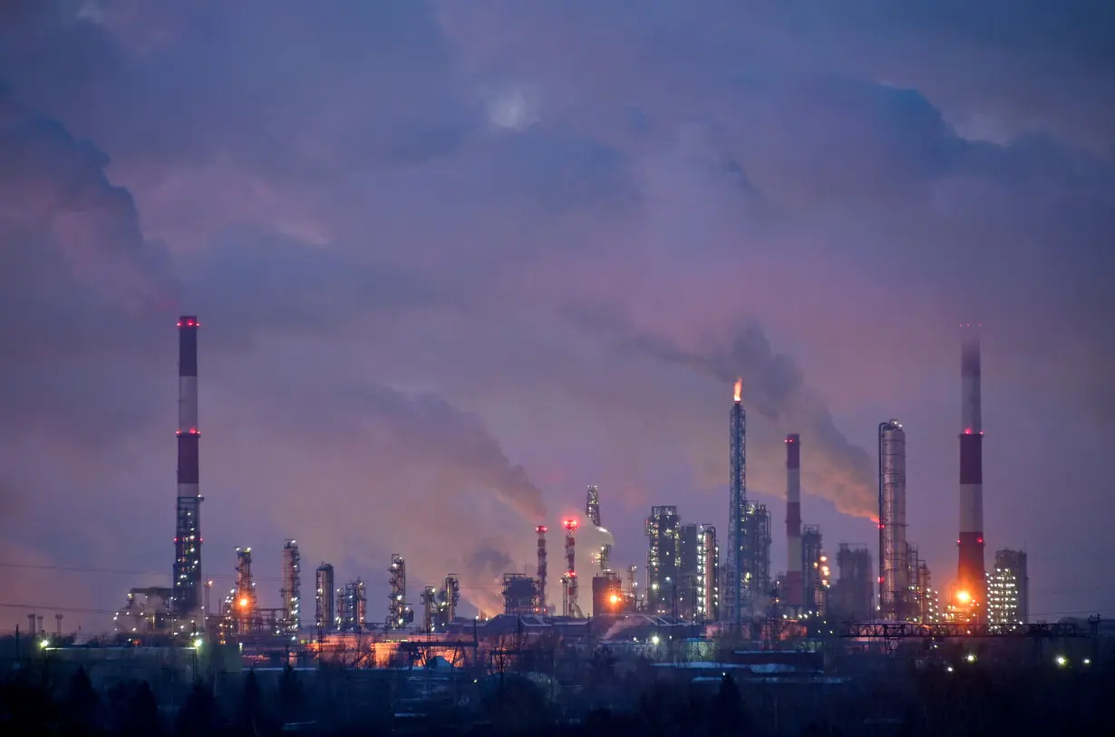 Flue gas and steam rise out of chimneys of an oil refinery in Omsk