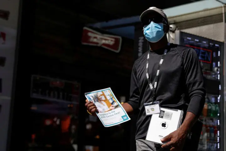 FILE PHOTO: A U.S. Census worker waits to take information from people during a promotional event in Times Square in New York