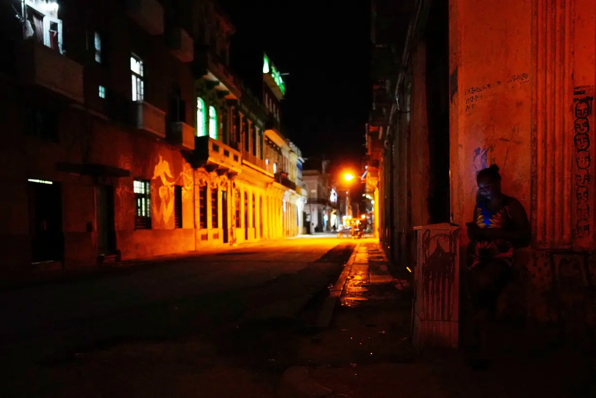 A woman uses her mobile phone in downtown Havana