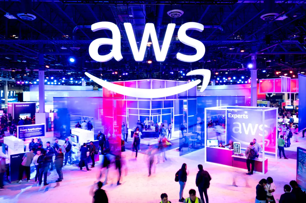 FILE PHOTO: Attendees walk through an expo hall at AWS re:Invent 2023, a conference hosted by Amazon Web Services (AWS), in Las Vegas