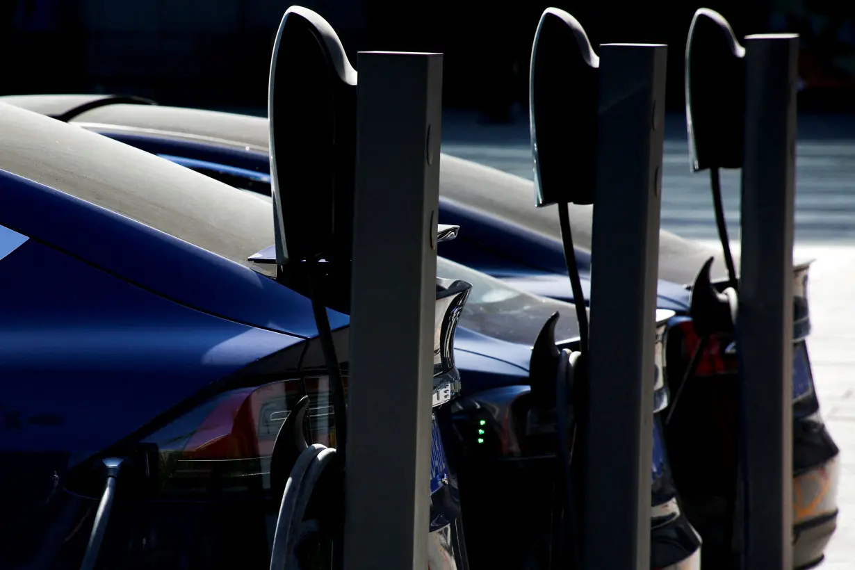 FILE PHOTO: Tesla cars charge at charging stations in Beijing