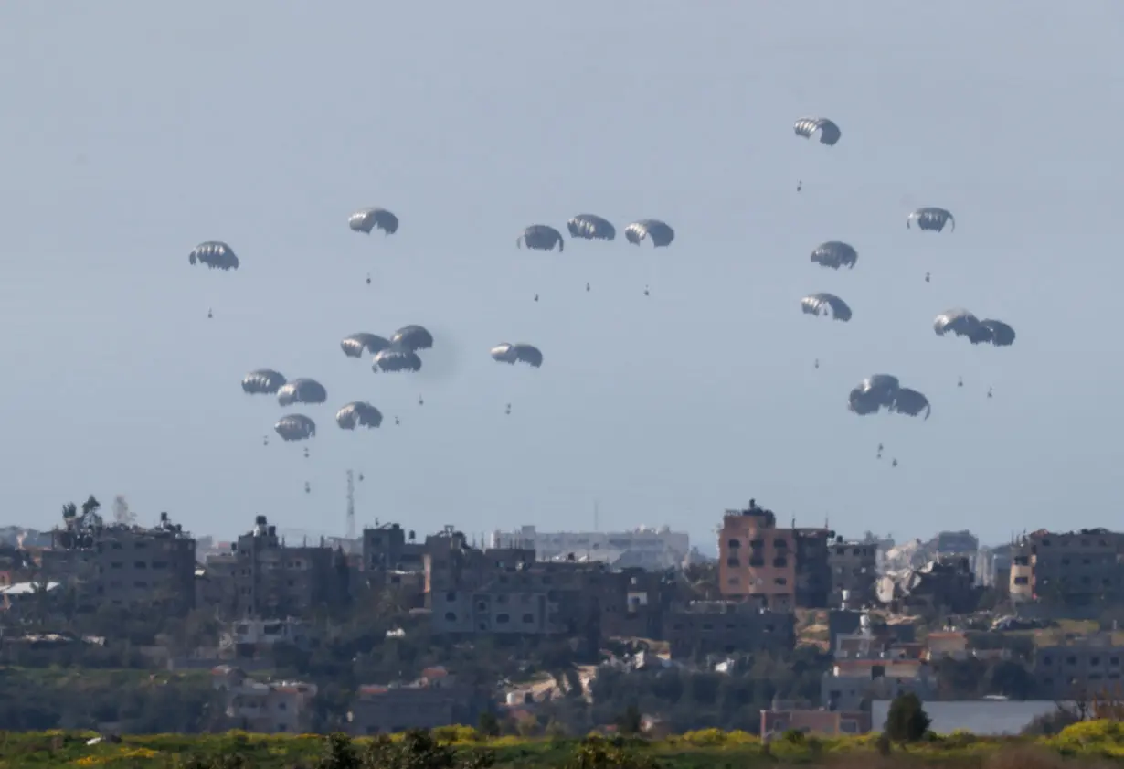 ksPackages dropped from a military aircraft fall towards Gaza, as seen from Israel