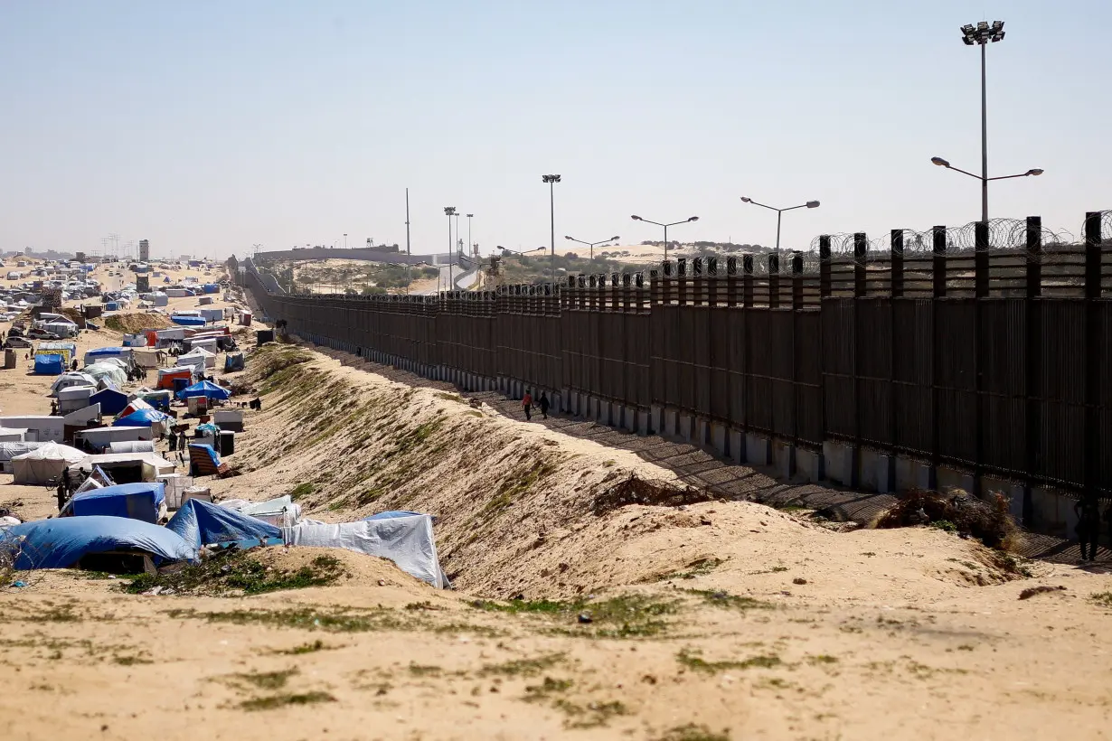 FILE PHOTO: Displaced Palestinians, who fled their houses due to Israeli strikes, shelter at a tent camp, in Rafah