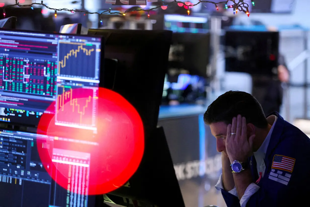 FILE PHOTO: A trader works on the trading floor at the New York Stock Exchange (NYSE) in New York City