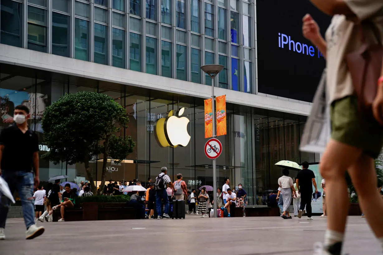 FILE PHOTO: People walk past an Apple store in Shanghai