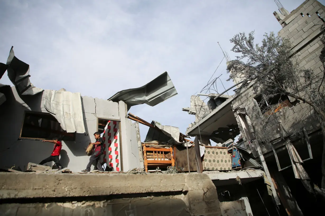 Palestinians inspect the site of an Israeli strike on a house in Rafah