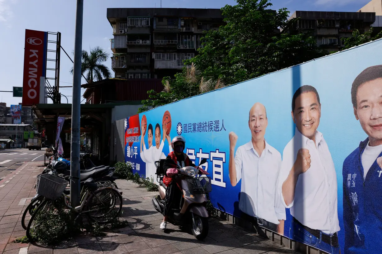 A person drives past a campaign ad for Hou Yu-ih, a candidate for Taiwan's presidency