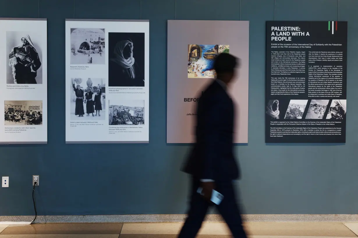 A man walks by a photo installation, amid the ongoing conflict between Israel and the Palestinian Islamist group Hamas, inside United Nations headquarters in New York City,