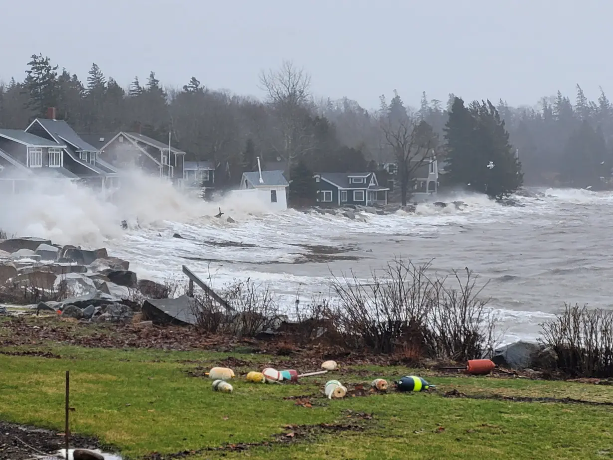 Water hits houses on a shore in Owls Head