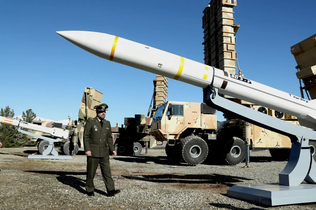 Iran's Defense Minister Brigadier General Mohammad-Reza Ashtiani walks near an Iranian missile during an unveiling ceremony in Tehran