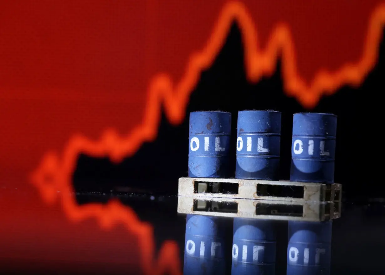 FILE PHOTO: Illustration shows Oil barrels in front of rising stock graph