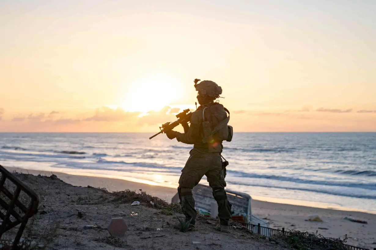 Israeli soldiers take position during the ongoing ground operation of the Israeli army against Palestinian Islamist group Hamas