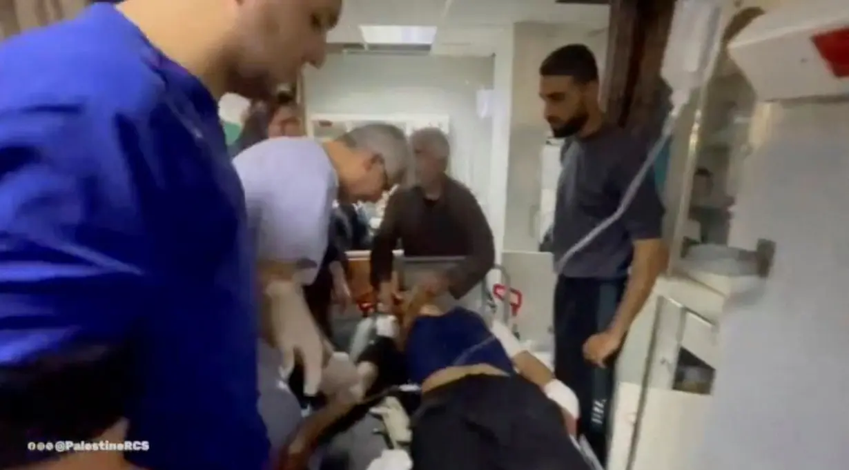 Medics treat wounded people at the Al-Amal Hospital, in Khan Younis