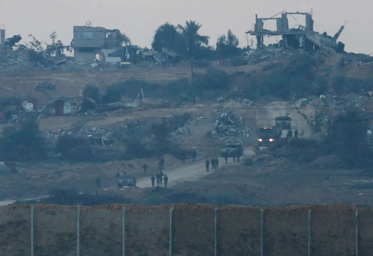 Israeli soldiers and vehicles move inside Gaza near the border with Israel