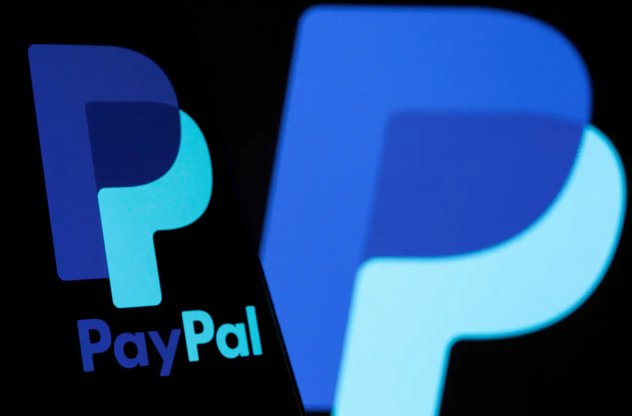 FILE PHOTO: The PayPal logo is seen on a smartphone in front of the same logo displayed in this illustration