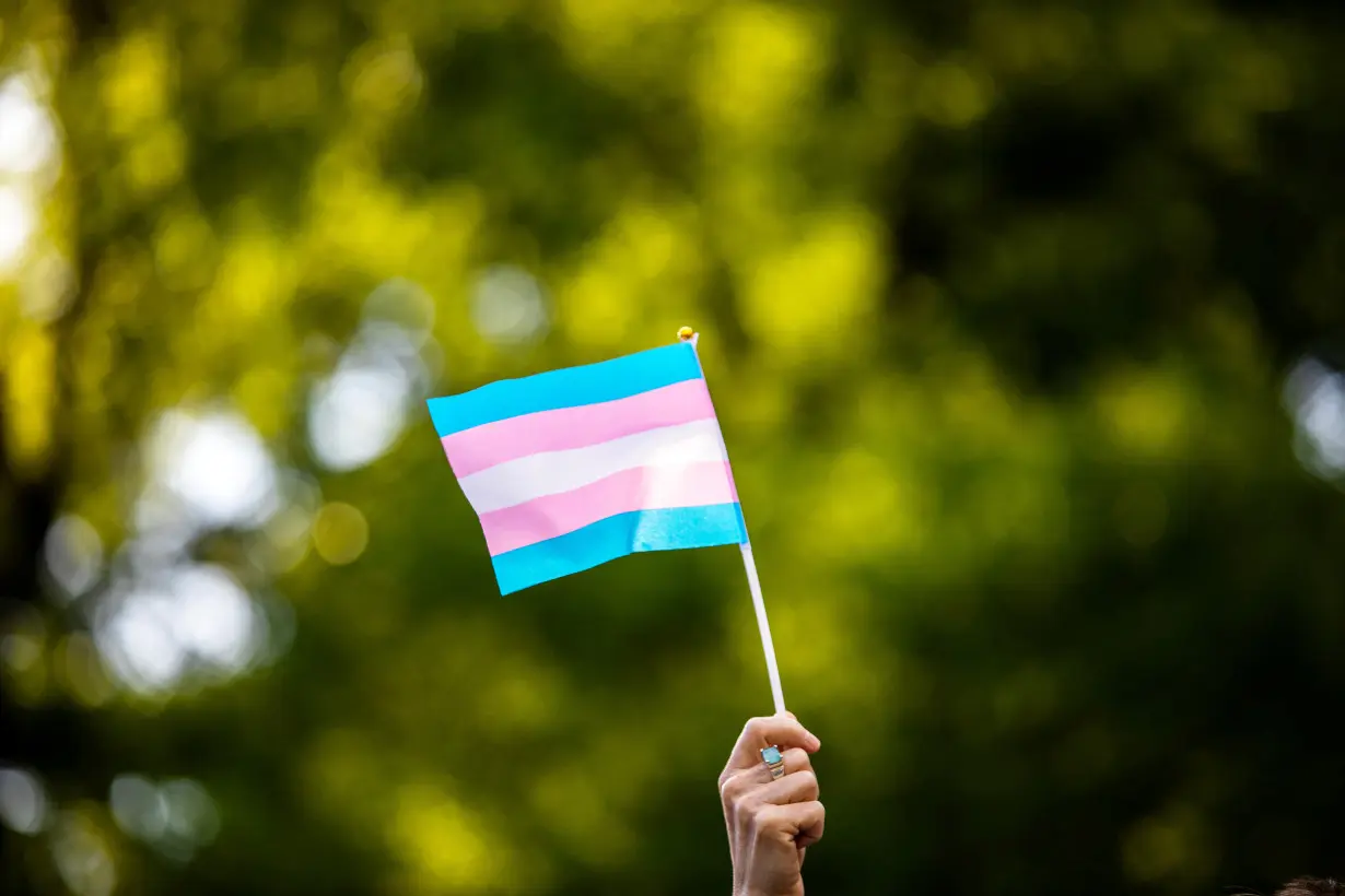 FILE PHOTO: Transgender rights activist waves a transgender flag as they protest the killings of transgender women this year, at a rally in Washington Square Park