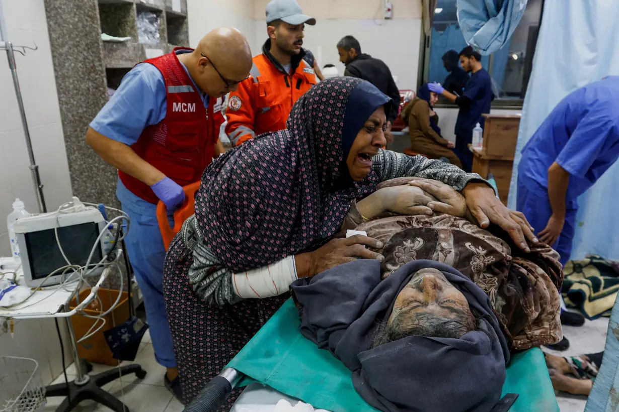 A Palestinian woman reacts next to a wounded man at Nasser hospital following Israeli strikes in Khan Younis