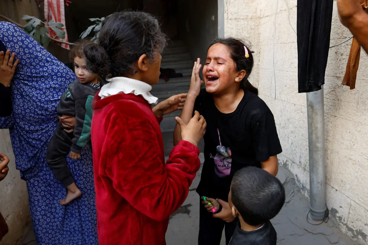 Palestinian children react after an Israeli strike on a house, amid the ongoing conflict between Israel and Palestinian Islamist group Hamas, in Khan Younis