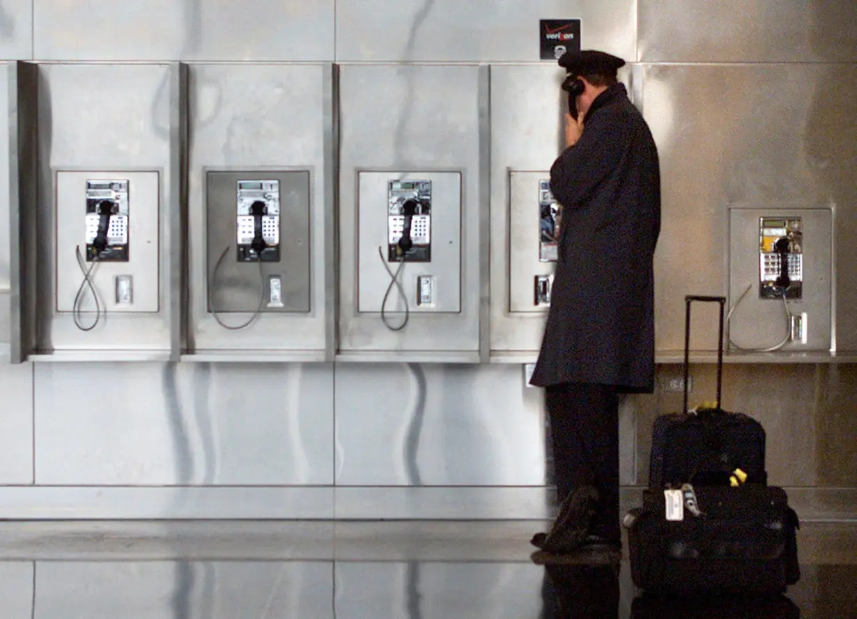 FILE PHOTO: A PILOT TALKS ON THE PHONE AT REAGAN NATIONAL AIRPORT NEAR WASHINGTON.