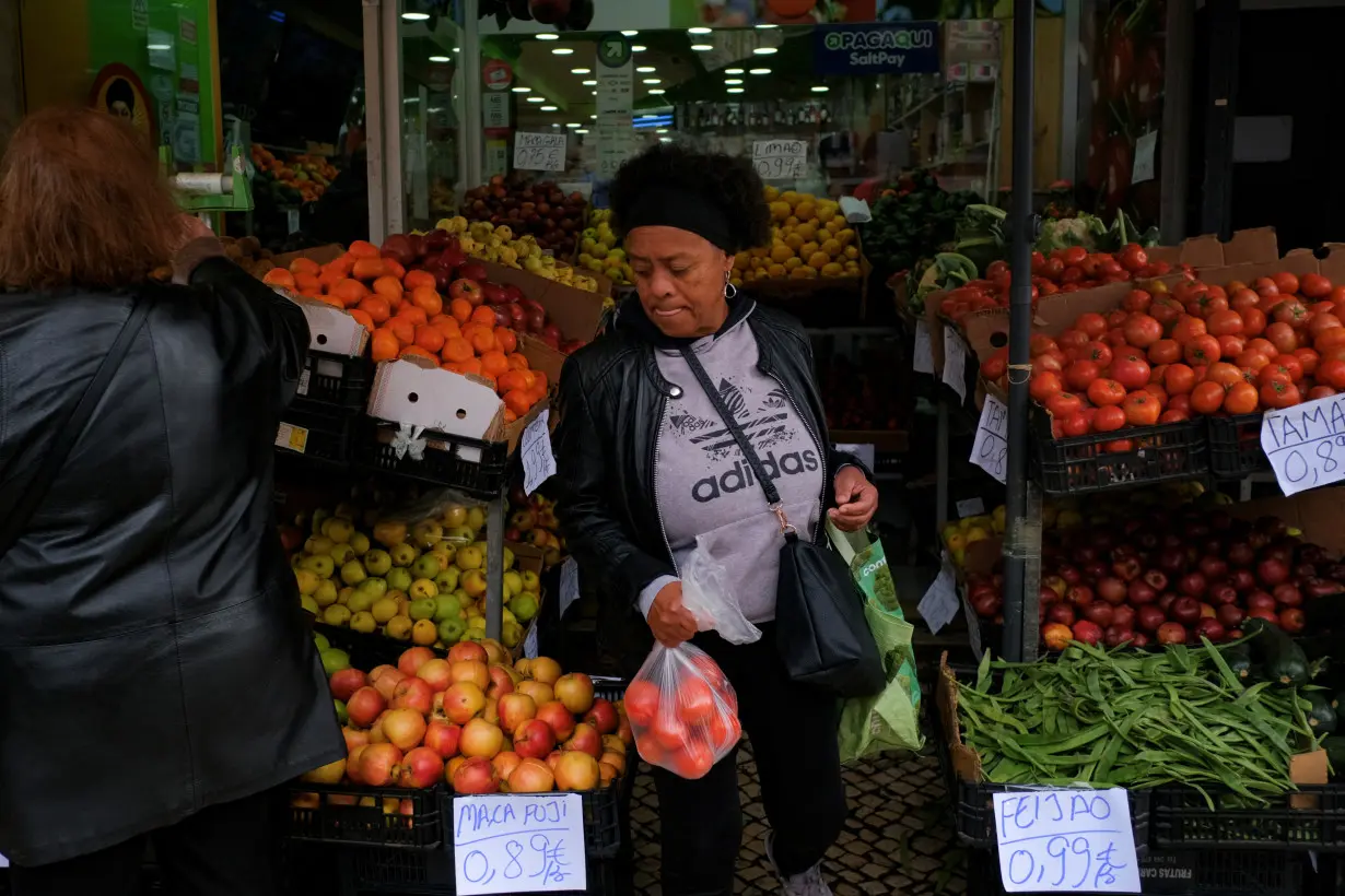 A woman buys groceries on the day the government is expected to unveil new measures to help families and companies in Lisbon