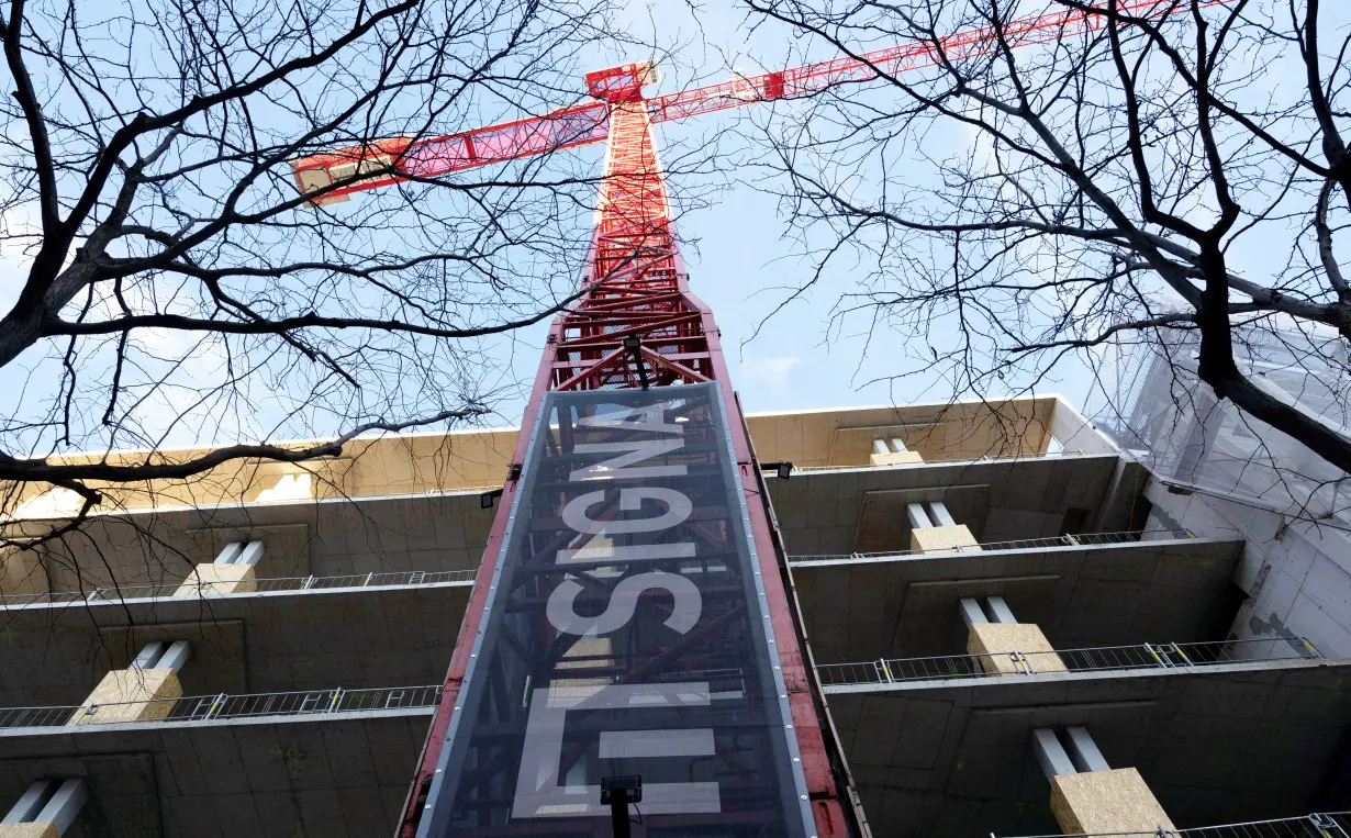 FILE PHOTO: The sign of Signa Holding is placed on a crane next to a construction site in Vienna