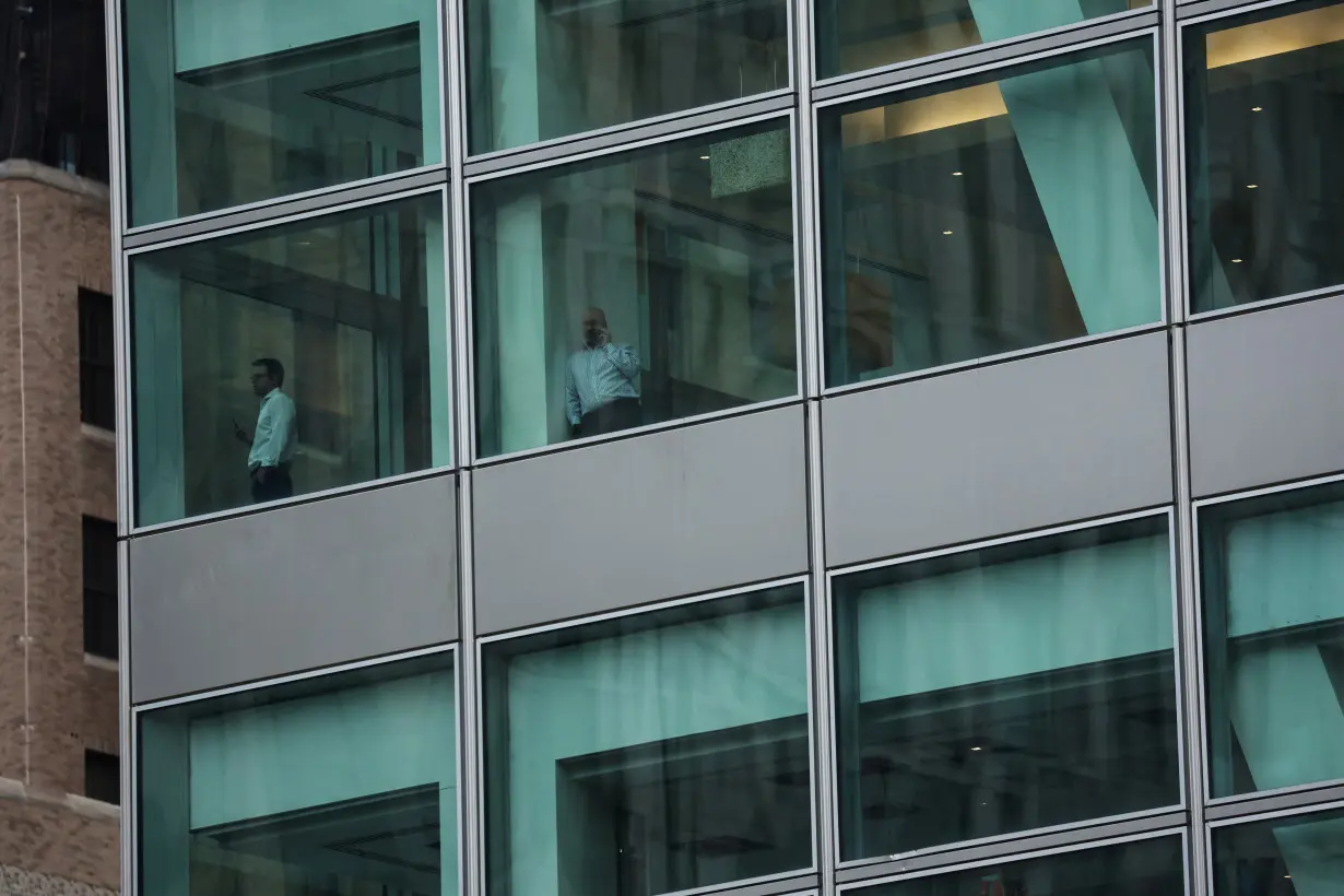 People stand on a floor at the global headquarters of Goldman Sachs investment banking firm in New York