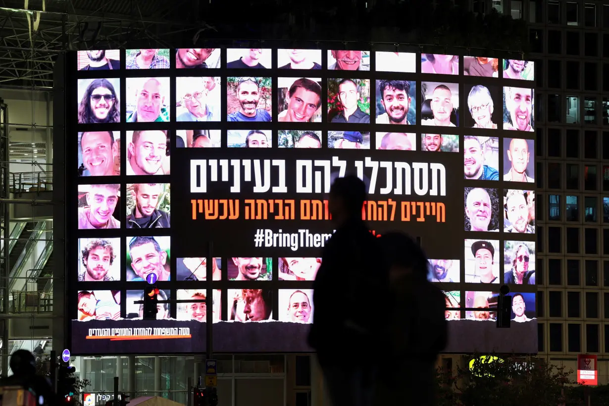 A screen displays photos of people who were abducted by Hamas gunmen during the October 7 attack on Israel, in Tel Aviv