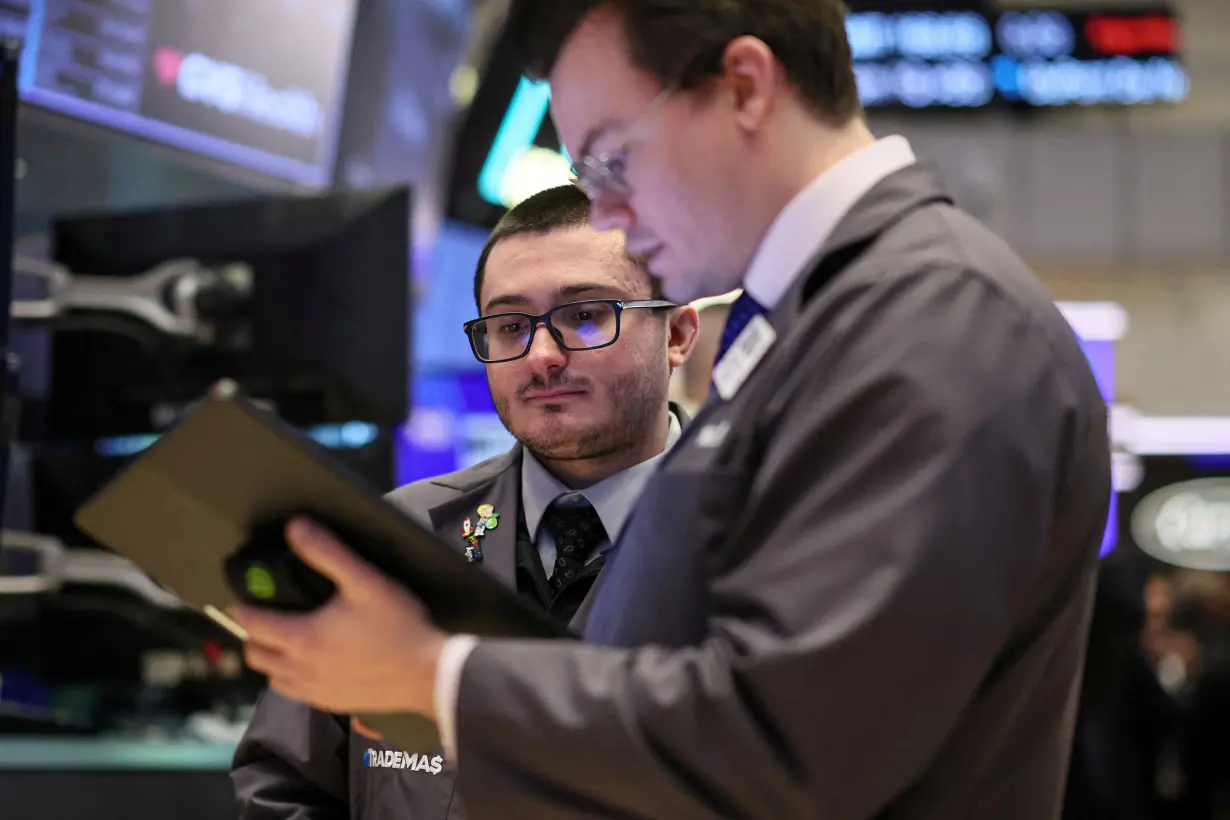 FILE PHOTO: Traders work on the floor of the NYSE in New York