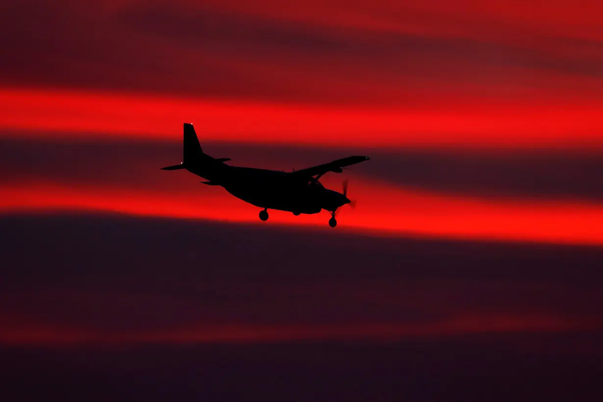 FILE PHOTO: A small propeller plane lands after sun set in San Diego, California