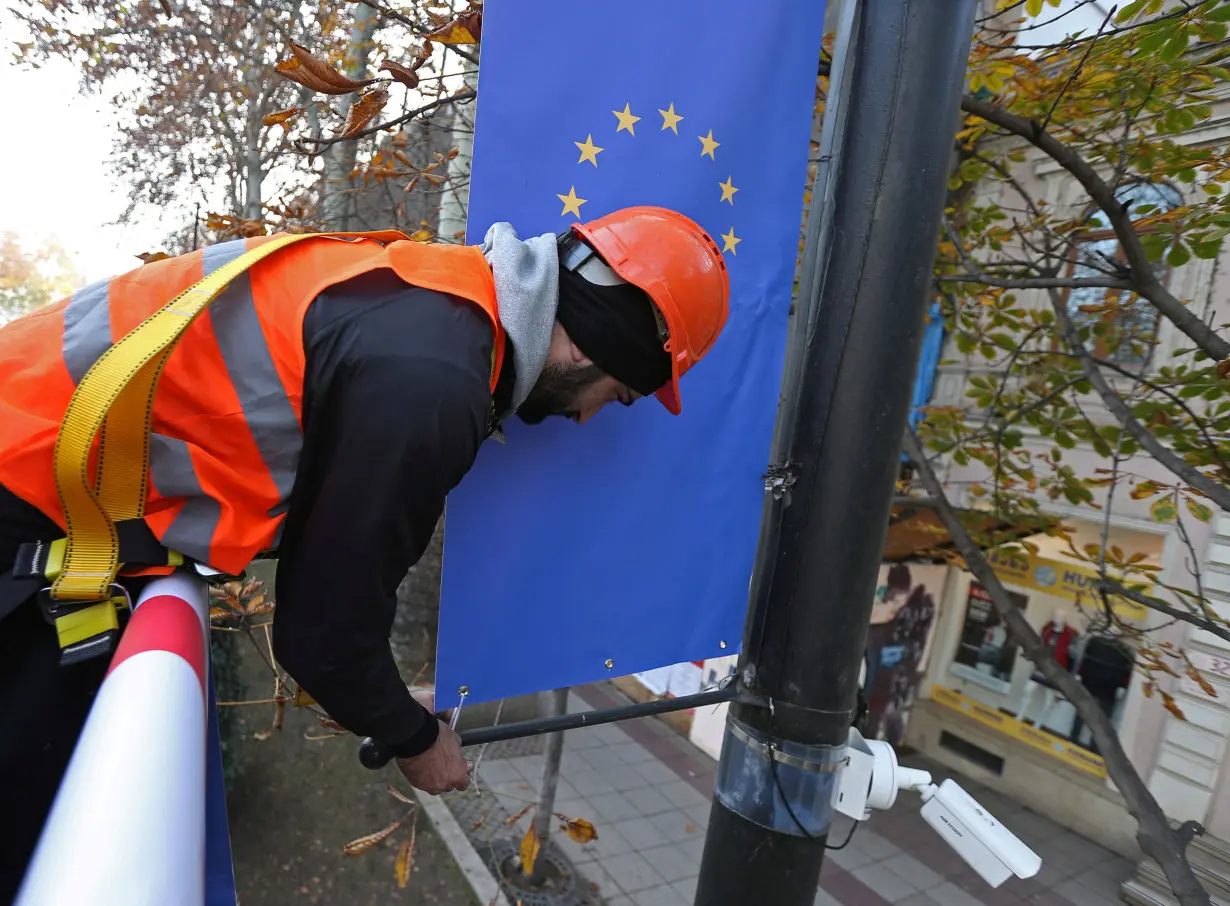 FILE PHOTO: A worker hangs a banner with a European Union flag in Tbilisi