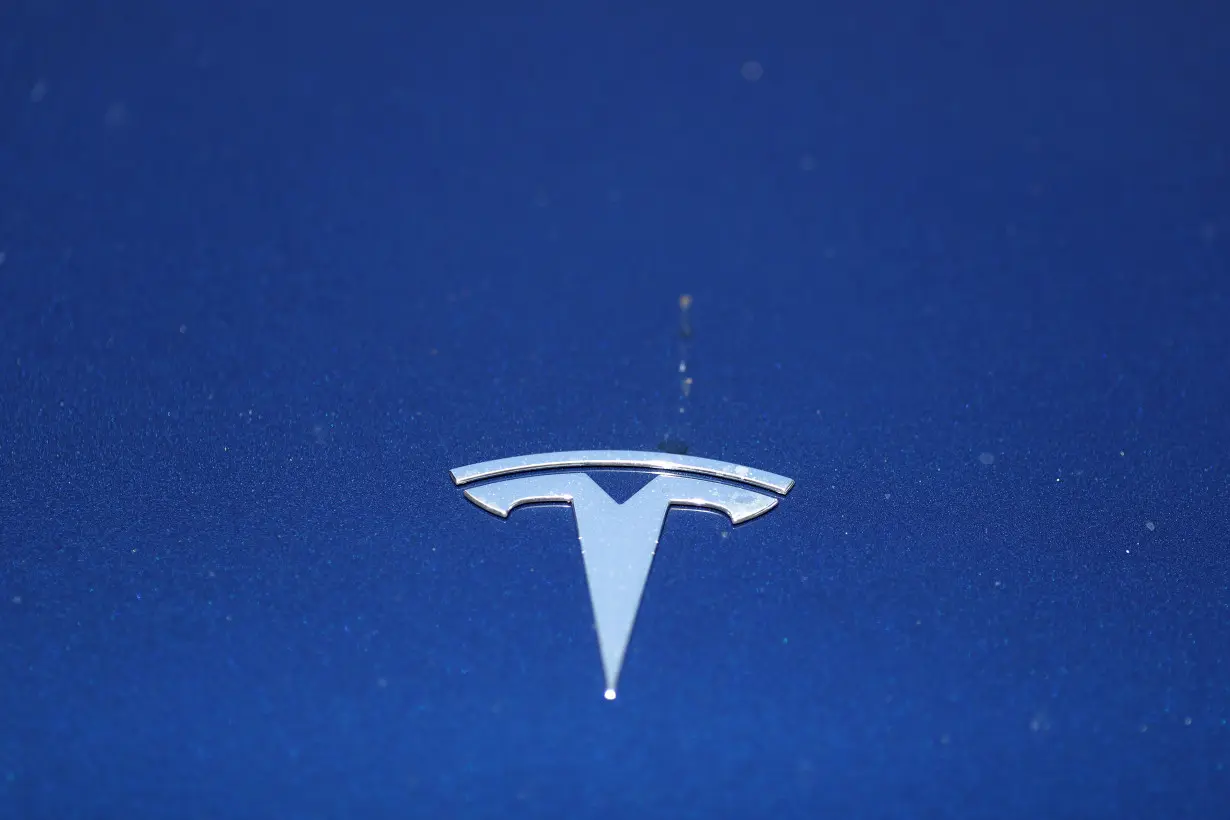 The Tesla logo is seen on a car in Los Angeles