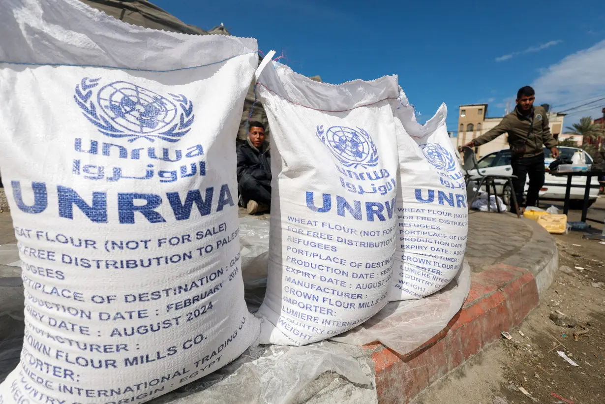 FILE PHOTO: Displaced Palestinians wait to receive United Nations Relief and Works Agency (UNRWA) aid, in Rafah