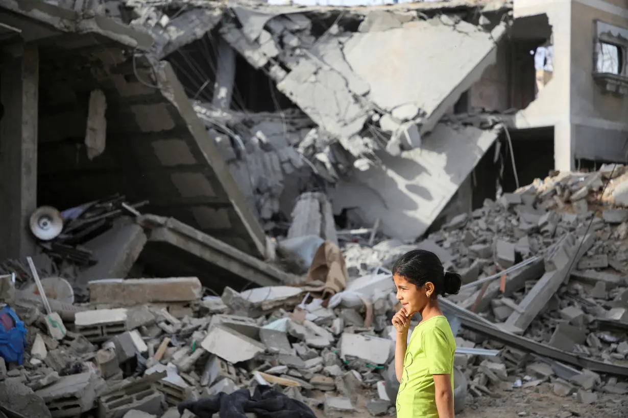 Palestinians inspect the site of an Israeli strike on a house in Rafah