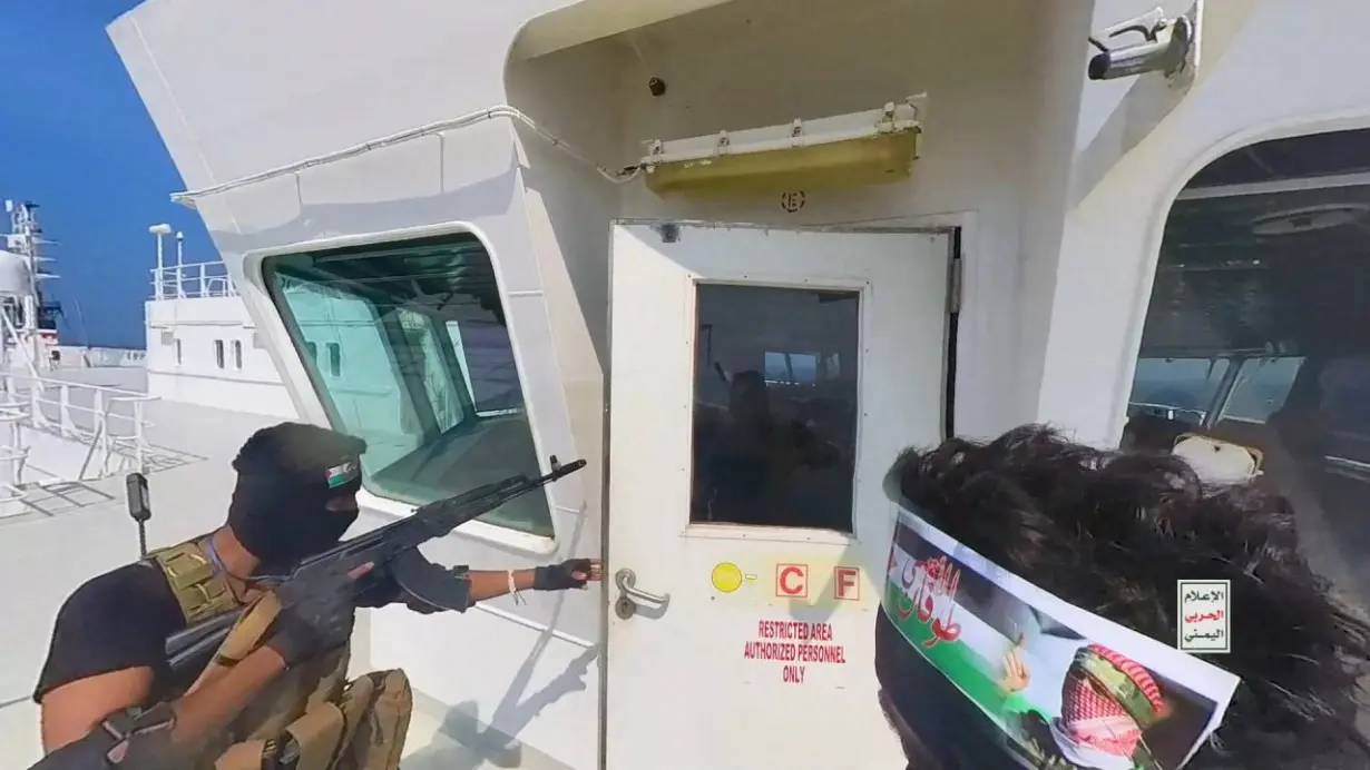 Houthi fighters open the door of cockpit on the ship's deck in the Red Sea