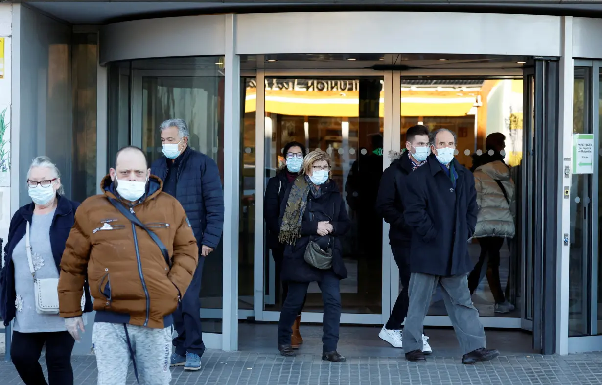 People wearing protective masks leave Germans Trias i Pujol Hospital in Badalona