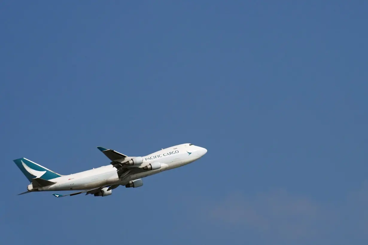 Cathay Pacific cargo aircraft flies over Hong Kong International Airport in Hong Kong