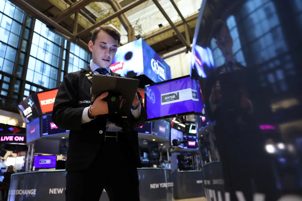 FILE PHOTO: A trader works on the trading floor at the New York Stock Exchange (NYSE) in New York City