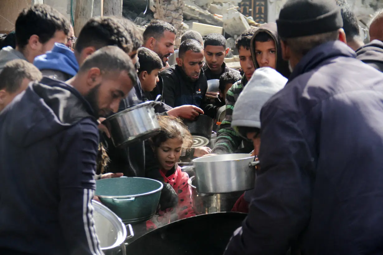 Palestinians gather to receive free food in Jabalia in the northern Gaza Strip