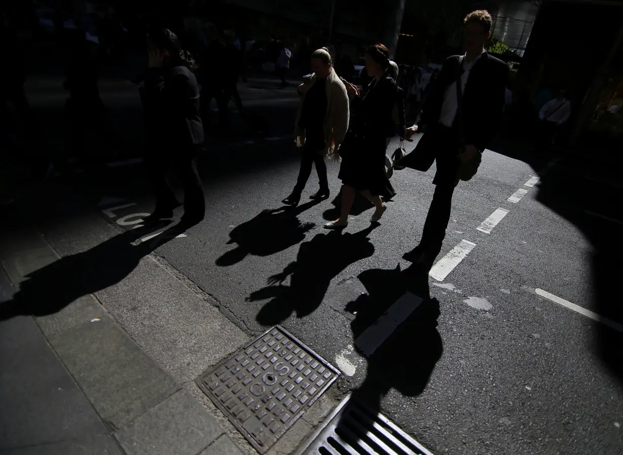 Office workers cross a street in Sydney