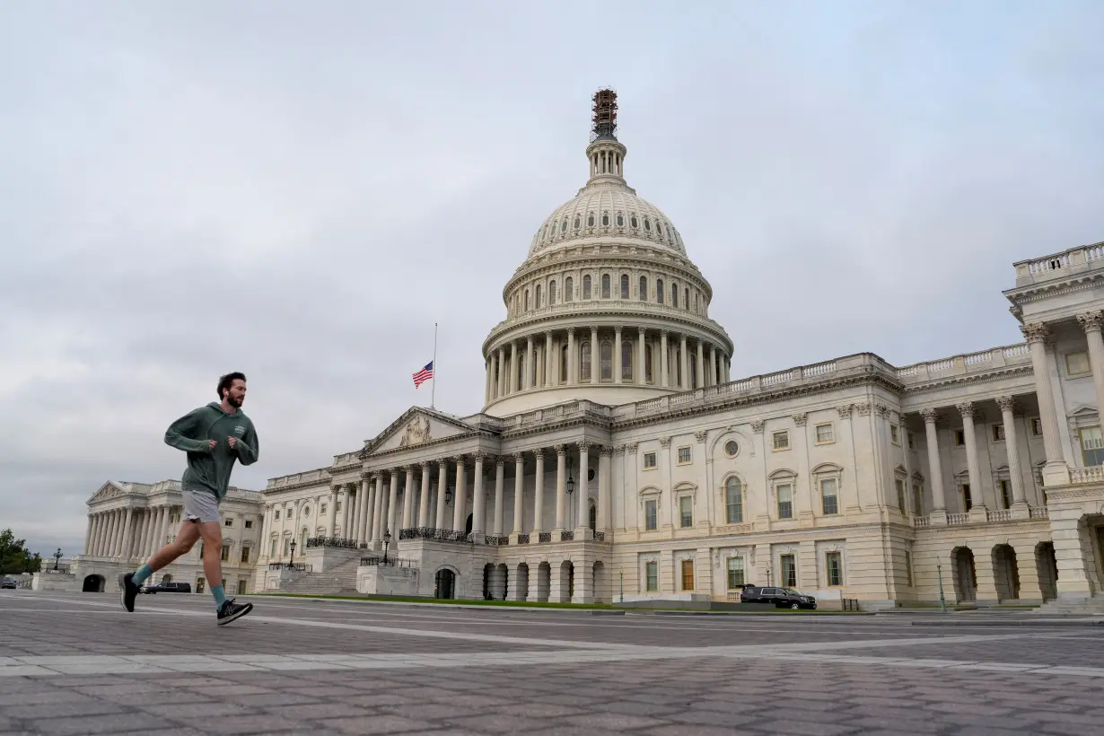 A jogger runs by the U.S. Capitol as the deadline to avert a partial government shutdown approaches at the end of the day on Capitol Hill