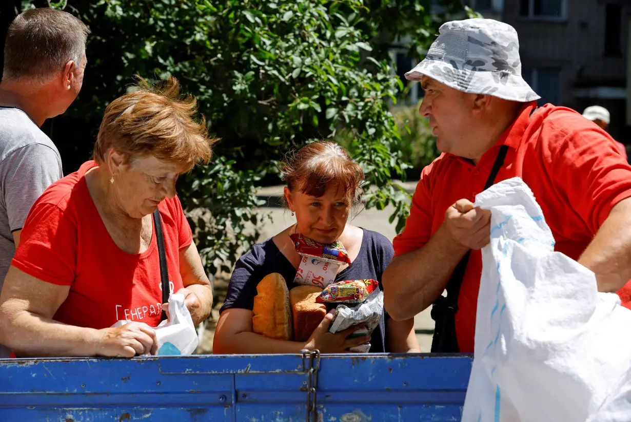 FILE PHOTO: Local residents receive water and food aid in Hola Prystan