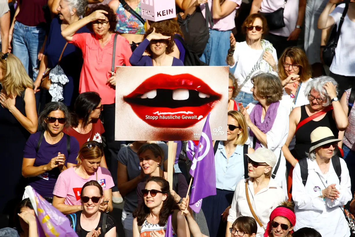 A protester carries a placard reading 