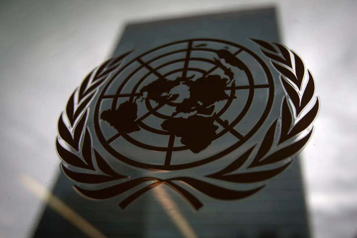 The United Nations headquarters building is pictured though a window with the UN logo in the foreground in the Manhattan borough of New York