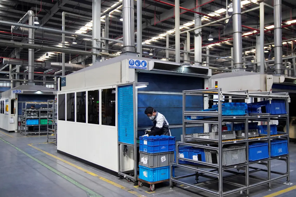 FILE PHOTO: Employee wearing a face mask works on a car seat assembly line at Yanfeng Adient factory in Shanghai