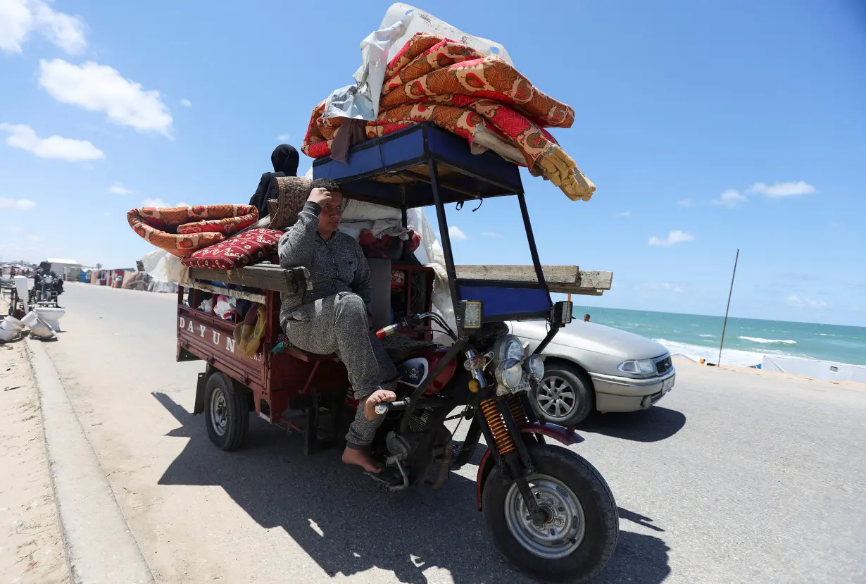 Displaced Palestinians who fled Rafah, ahead of a threatened Israeli assault, travel in Al-Mawasi area, in Khan Younis